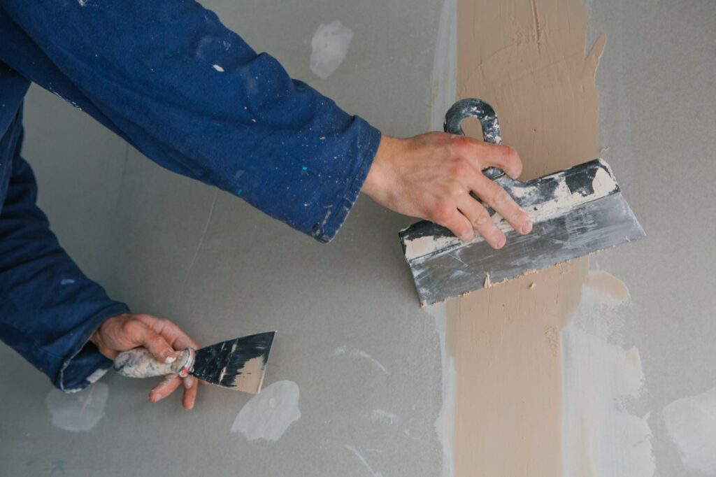 Spachtelarbeiten an einer Gipskartonwand für eine glatte Oberfläche